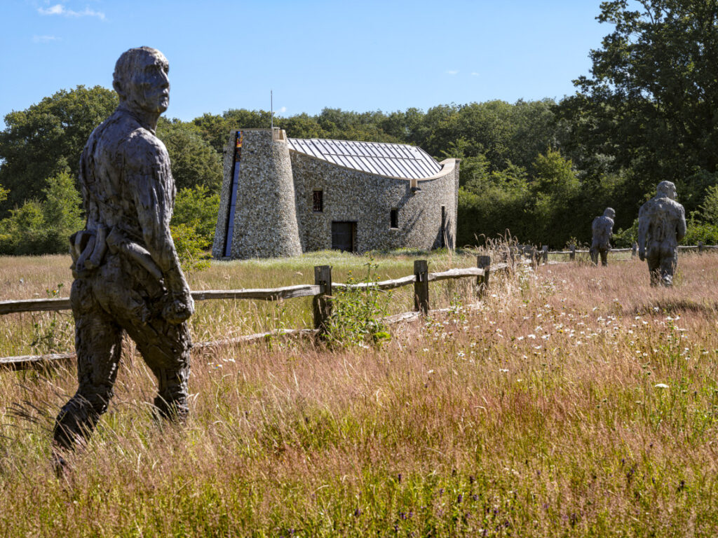 Chapel in the background with statues of walking men in the foreground